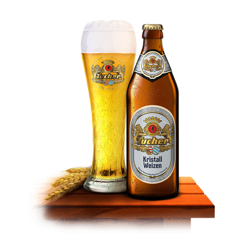 A full glass of beer stands next to a closed bottle on a wooden table.