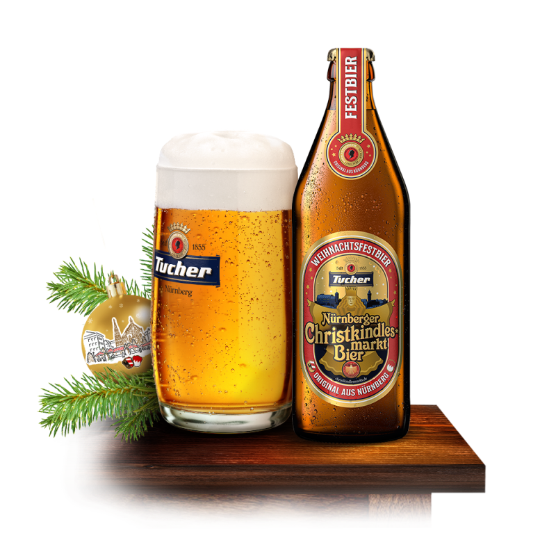 A glass filled with golden beer next to a beer bottle sits on a wooden table.