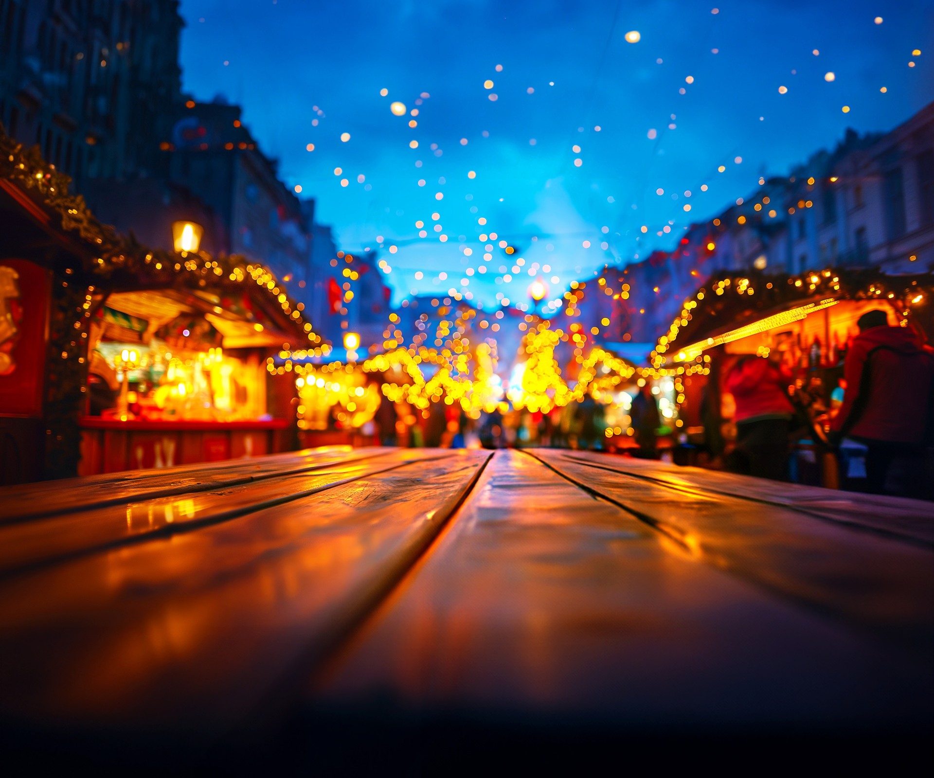 A bustling Christmas market at night, illuminated by colorful lights and lanterns.