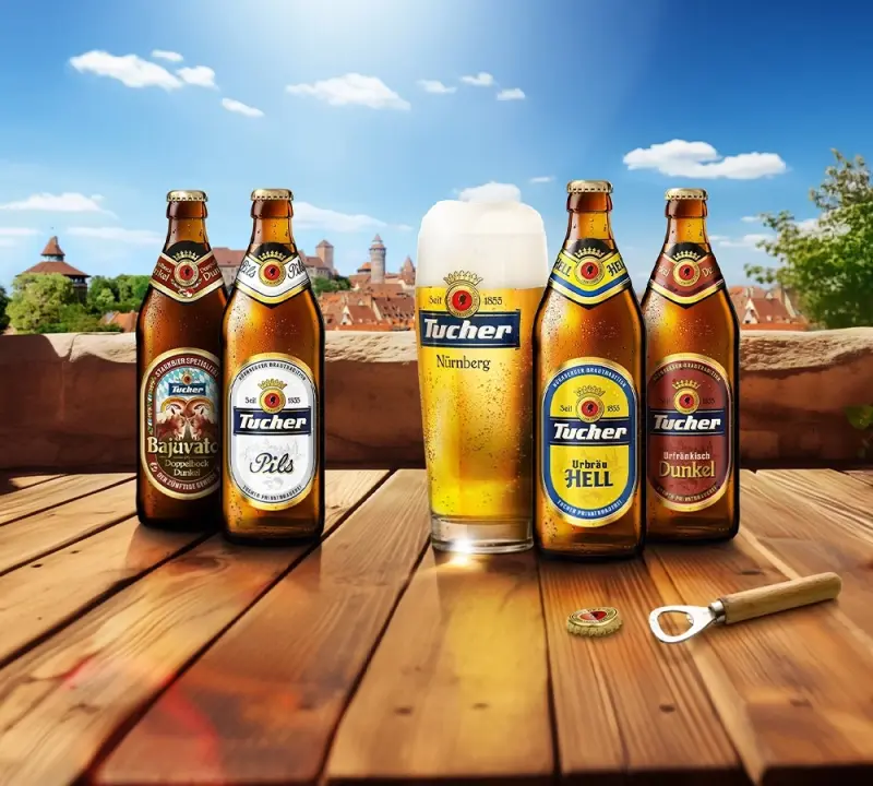 Four beer bottles and a full glass stand on a wooden table in front of a city view.
